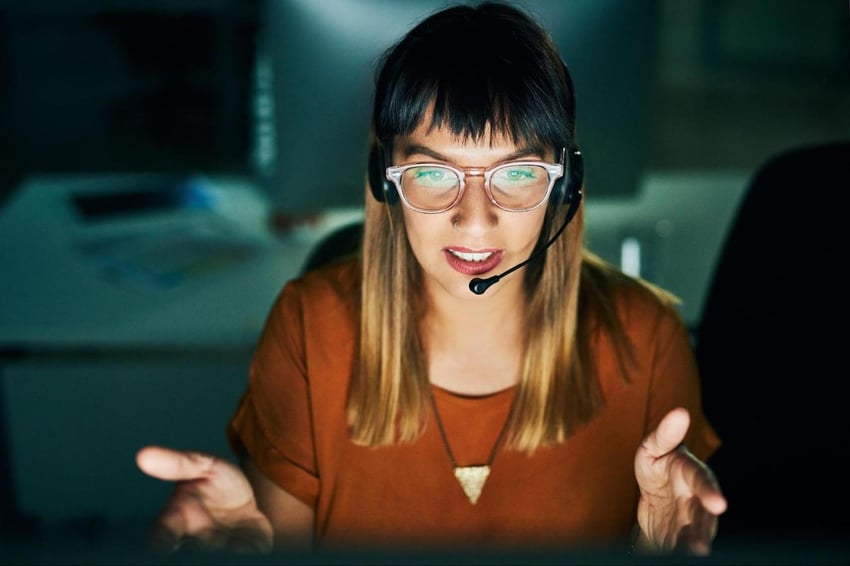 contact centre agent gestures while talking in darkened office contact centre agent gestures while talking in darkened office