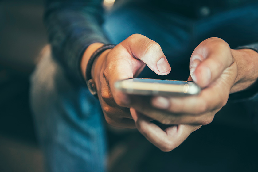 938786704 Persona enviando mensaje de texto en teléfono móvil